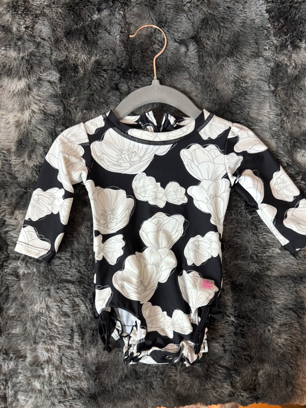 Rufflebutts Black Floral Long Sleeve Rashguard Swimsuit with White Flower Print
